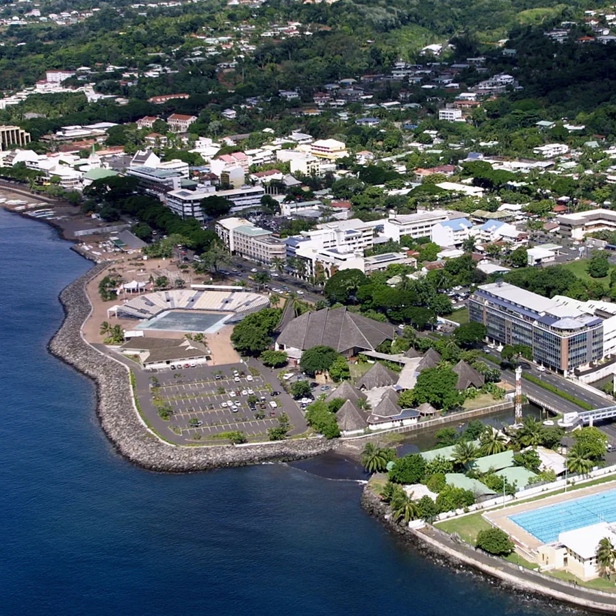 Vue aérienne de Papeete Ouest : le front de mer de Toata, la piscine, et les hauteurs résidentielles au-dessus de la ville