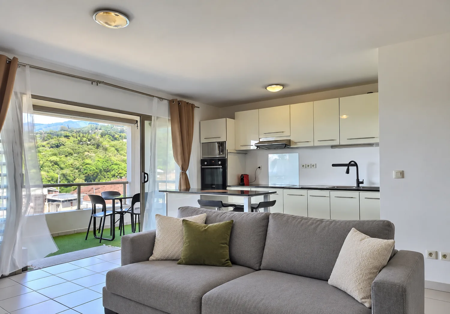 Séjour de l'appartement vendu, ouvert sur la cuisine et la terrasse